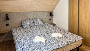 A bedroom with a bed, wooden ceiling, and a wardrobe. - Cozy home in Zuromino with WiFi (Zuromino)