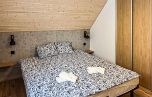 A bedroom with a bed, wooden ceiling, and a wardrobe. - Cozy home in Zuromino with WiFi (Zuromino)