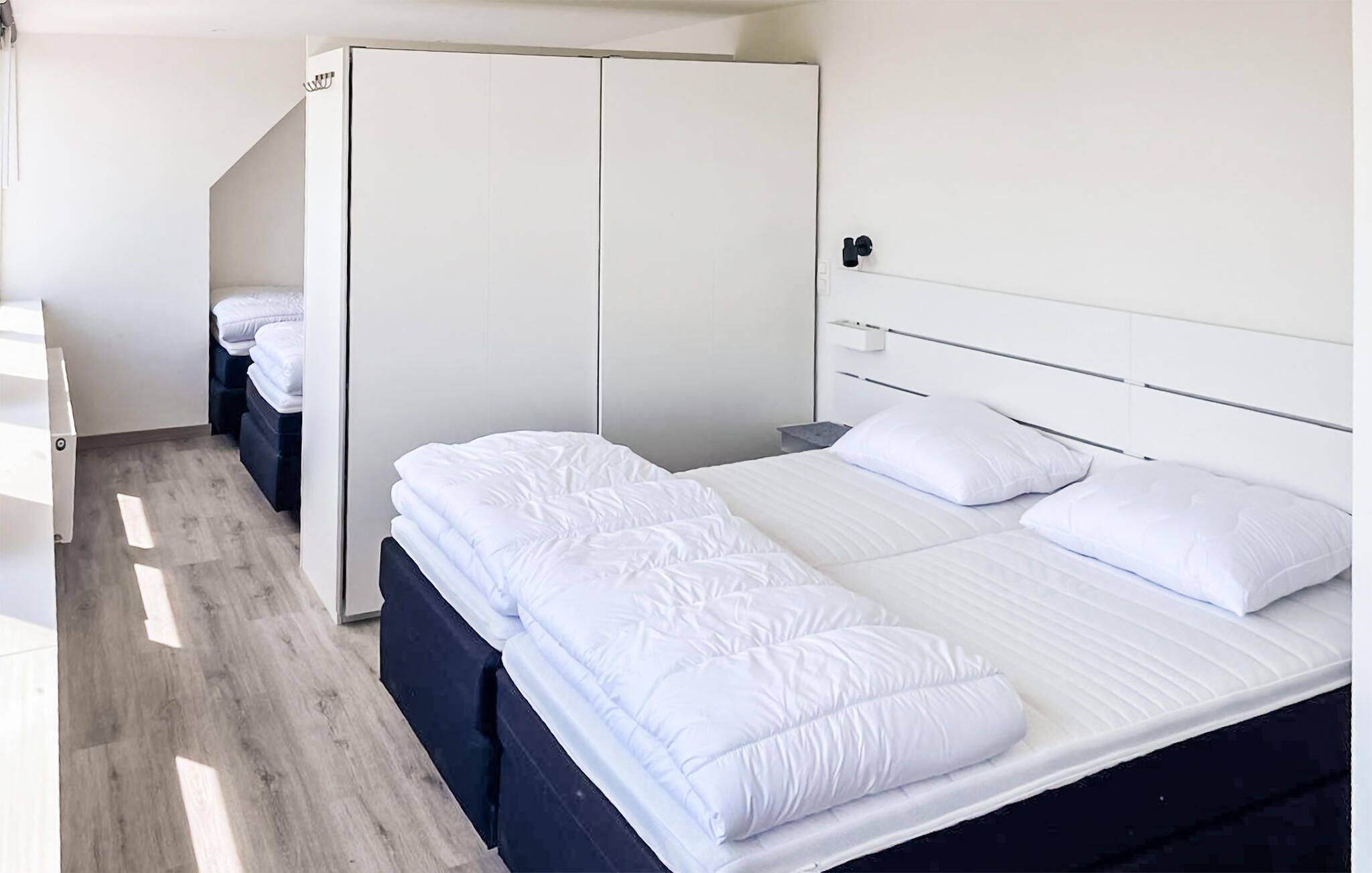 A bedroom with a bed, a wardrobe, and a nightstand.