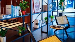 A modern interior with a bookshelf, chairs, and potted plants. - The Journey Hotel Penang (George Town)