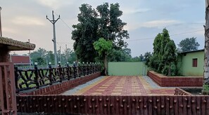 Una terraza en la azotea con suelo estampado, valla de madera y pared verde.