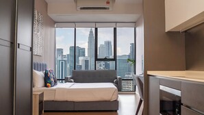 Ein modernes Schlafzimmer mit Blick auf die Stadt, ausgestattet mit einem Bett, einem Schreibtisch und einem Einbauofen.