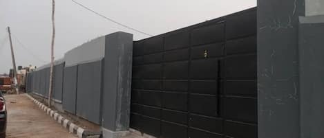 Una pared larga y oscura con una puerta de garaje grande.
