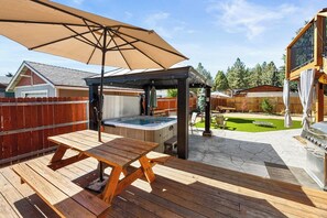 En träaltan med ett picknickbord och en bubbelpool.
