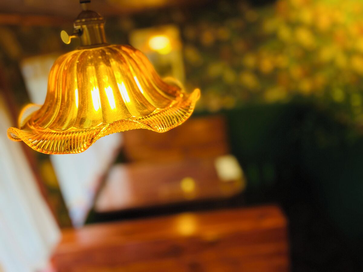 Gros plan d’un luminaire suspendu diffusant une lumière chaleureuse.