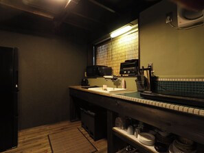 A compact kitchen with a microwave, coffee maker, and a sink.