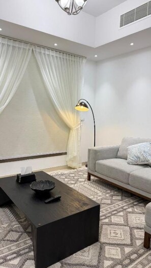 Appartement Luxe | Coin séjour | TV connectée de 65 pouces avec chaînes numériques