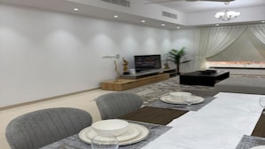 Uma sala de estar moderna com área de jantar preparada para uma refeição.