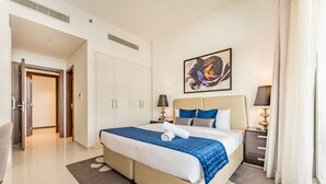 A hotel room with a large bed, a painting on the wall, and a view of the hallway. - Contemporary 2BR, Mins. Drive to Butterfly Garden (Dubai)
