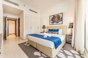 A hotel room with a large bed, a painting on the wall, and a view of the hallway. - Contemporary 2BR, Mins. Drive to Butterfly Garden (Dubai)