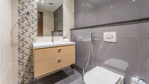 A modern bathroom with a vanity, a toilet, and a shower. - Contemporary 2BR, Mins. Drive to Butterfly Garden (Dubai)