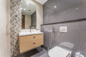 A modern bathroom with a vanity, a toilet, and a shower. - Contemporary 2BR, Mins. Drive to Butterfly Garden (Dubai)