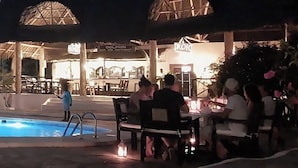 A poolside area with outdoor seating and a restaurant in the background. - 2 Livu Villas Watamu (Watamu)
