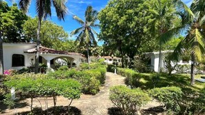 A courtyard with a pathway, palm trees, and a building with arches. - 2 Livu Villas Watamu (Watamu)