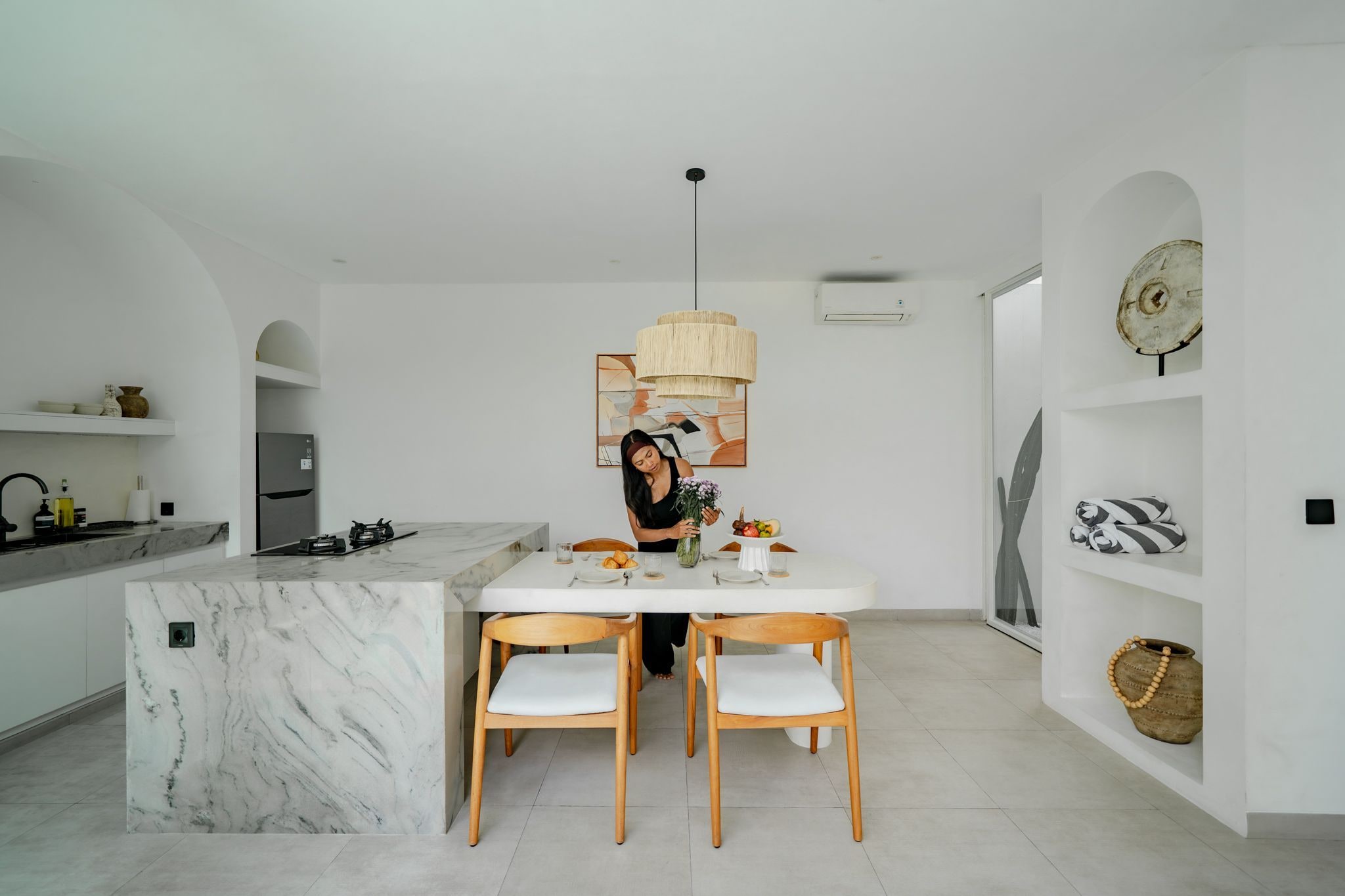 Una cucina moderna con isola in marmo, sedie in legno e tavolo da pranzo.