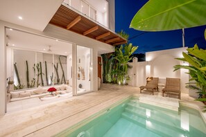 A modern outdoor pool area with a seating area and plants. - The Belluoccio Villa (Canggu)