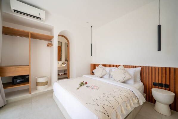 A modern bedroom with a bed, bedside table, and a built-in wardrobe. - The Belluoccio Villa (Canggu)