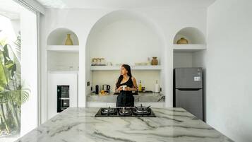 Una cocina moderna con encimera de mármol, cocina a gas y refrigerador.