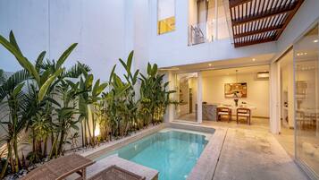 Una piscina al aire libre, tumbonas