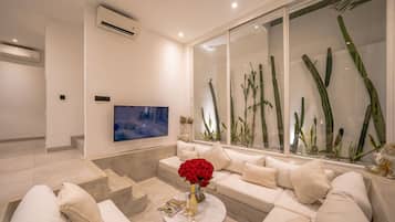 Una sala moderna con un sofá, una mesa de centro y un televisor de pantalla plana.