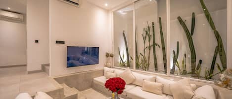 A modern living room with a sofa, coffee table, and a flat-screen TV.