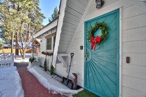 A house with a turquoise door, a snow-covered pathway, and a white picket fence. - The cabin is located close to many of Big Bear's most popular attractions (Big Bear)