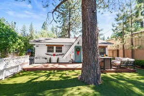A residential property with a white house, a fenced yard, and a large tree. - The cabin is located close to many of Big Bear's most popular attractions (Big Bear)