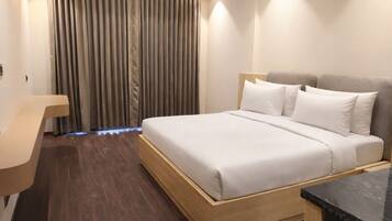 Rom – deluxe, byutsikt | Skrivebord, skrivebord for bærbar PC, blendingsgardiner og lydisolert