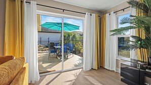 Un salon moderne doté d’une porte-fenêtre coulissante donnant sur un patio extérieur.