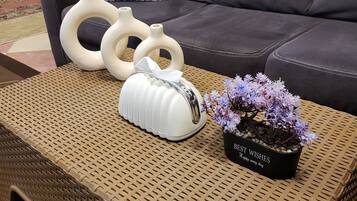 A wicker coffee table with a potted plant and decorative vases.