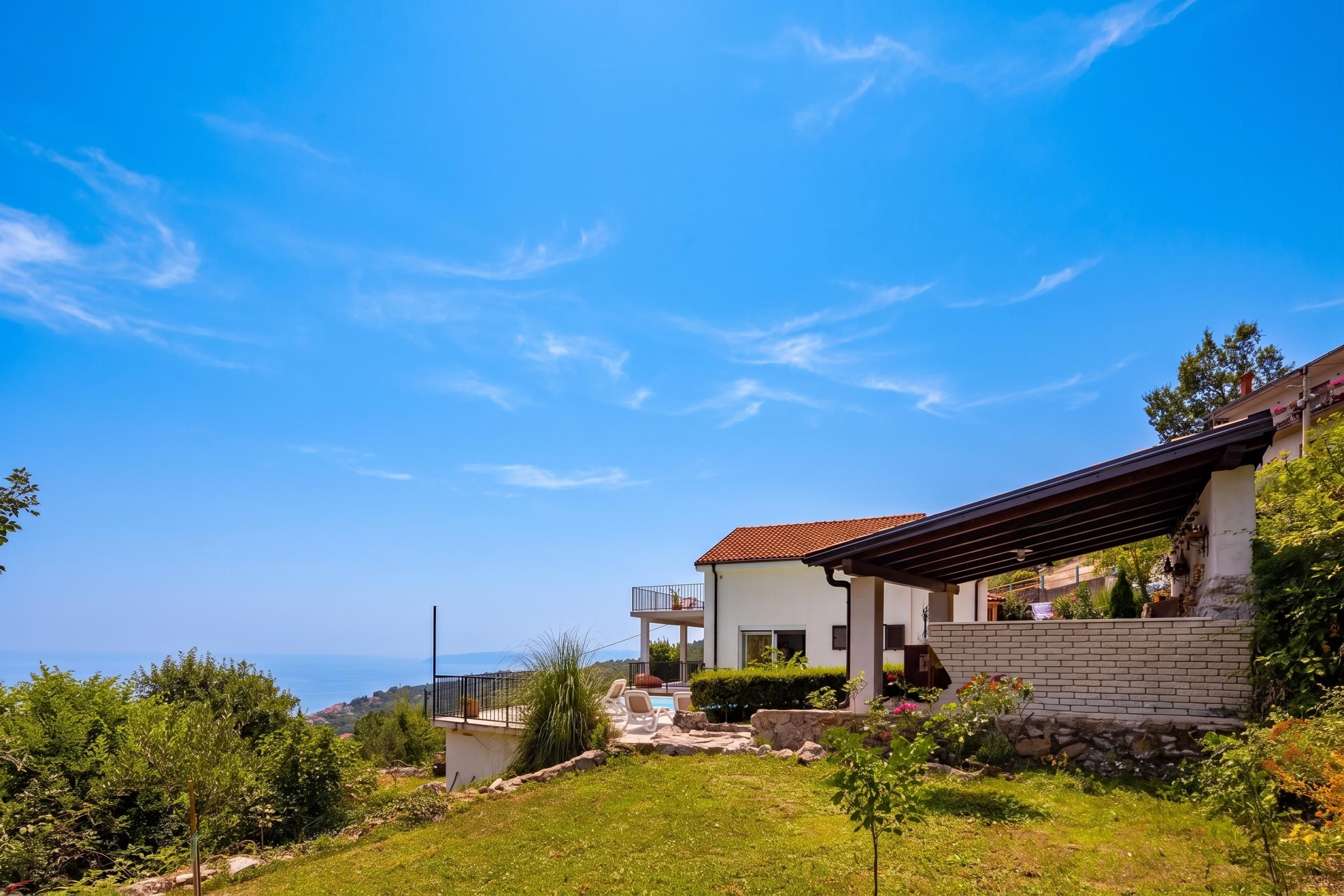 Una casa moderna con piscina, immersa nel verde sotto un cielo sereno.