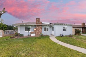 A single-story house with a brick chimney, a front porch, and a well-maintained lawn. - Near Hospital / West Covina Renovated 4BR (West Covina)
