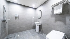 A modern bathroom with a shower, sink, and toilet. - Dubai Hotel Dangjin (Dangjin)