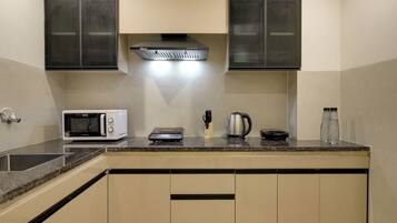 Departamento ejecutivo, balcón | Cocina privada | Refrigerador con congelador, microondas y utensilios de cocina