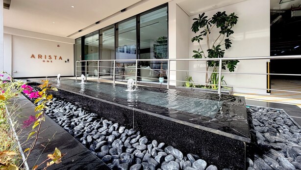 Un edificio moderno con fuente de agua, zona de recepción y plantas de interior.