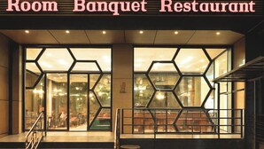 The exterior of the OM Vilas Room Banquet Restaurant with a modern design, featuring hexagonal glass windows and a staircase leading to the entrance. - Hotel Om Vilas (Mathura)