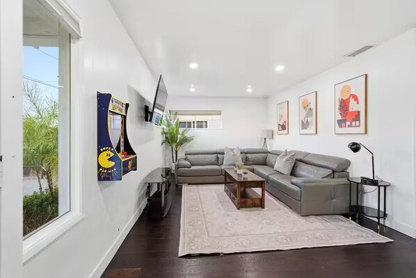 A modern living room with a grey sofa, a coffee table, and artwork on the walls.