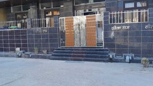 A building entrance with a metal gate, steps, and a nameplate. - BABA SITARAM ASHRAM (Haridwar)