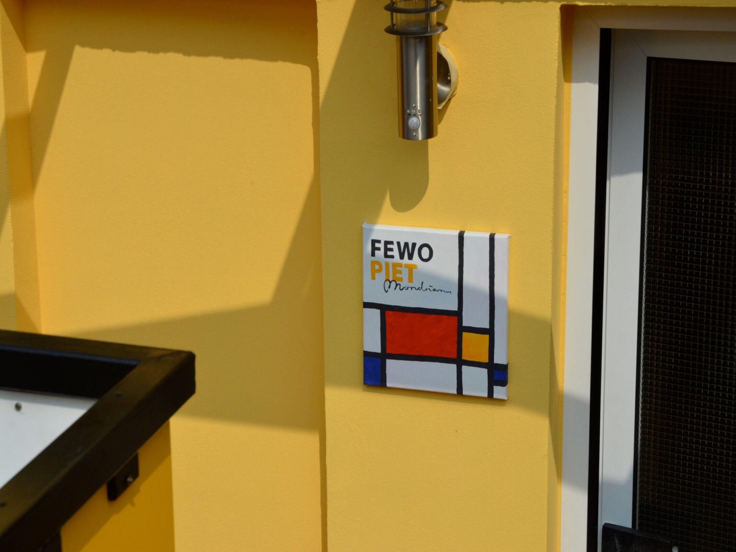 A yellow wall with a sign reading "FEWO PIET Mondrian".