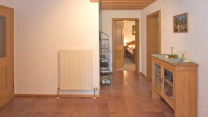 A hallway with a radiator, wooden ceiling, and a cabinet with glass doors. - Ferienwohnung im Bayerischen Wald mit Whirlpool (Waldkirchen)