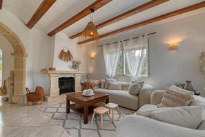 A living room with a fireplace, a sofa, a coffee table, and a baby carriage. - Nova - Javea, Costa Blanca (Javea)