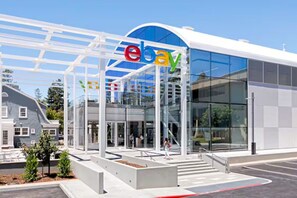 Ein moderner eBay-Shop mit Glasfassade und weißer Außenwand.