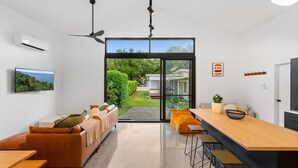 Una sala de estar moderna con un sofá, una mesa de comedor y una zona de cocina.