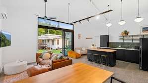 Una cocina moderna con barra, una mesa de comedor y una zona de estar con sofá y sillas.
