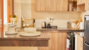 A modern kitchen with wooden cabinets, a granite countertop, and a stainless steel refrigerator. - 2-bedroom apartment with Lake views and a heated pool in Nakuru Town (Nakuru)