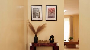 A hallway with a wooden console table, two framed pictures, and a vase with pampas grass. - 2-bedroom apartment with Lake views and a heated pool in Nakuru Town (Nakuru)