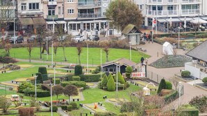 A park with a miniature golf course, a small building, and a statue. - Cozy four bedroom apartment by the harbor (Blankenberge)