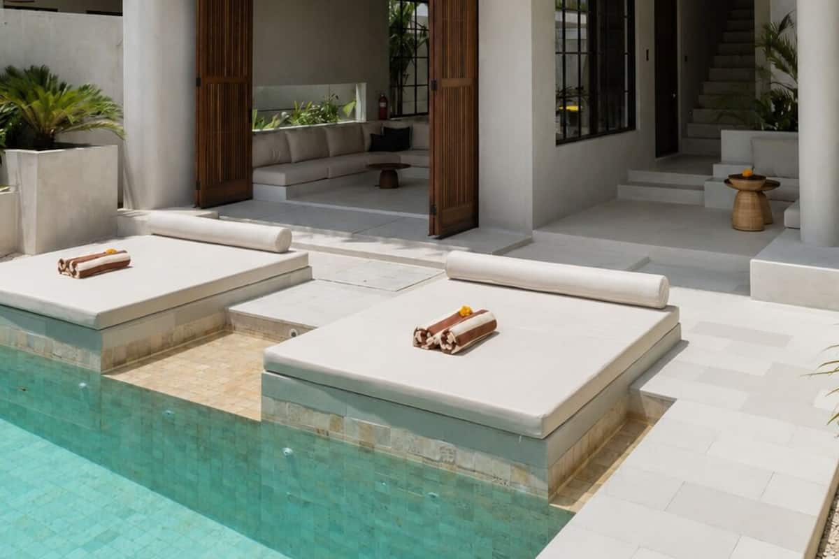 A modern two-story house with a swimming pool, outdoor seating, and a staircase leading to an upper level.