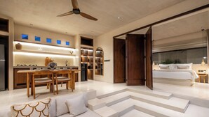 Een modern interieur met een eethoek, keuken en een slaapkamer met een groot bed en uitzicht.