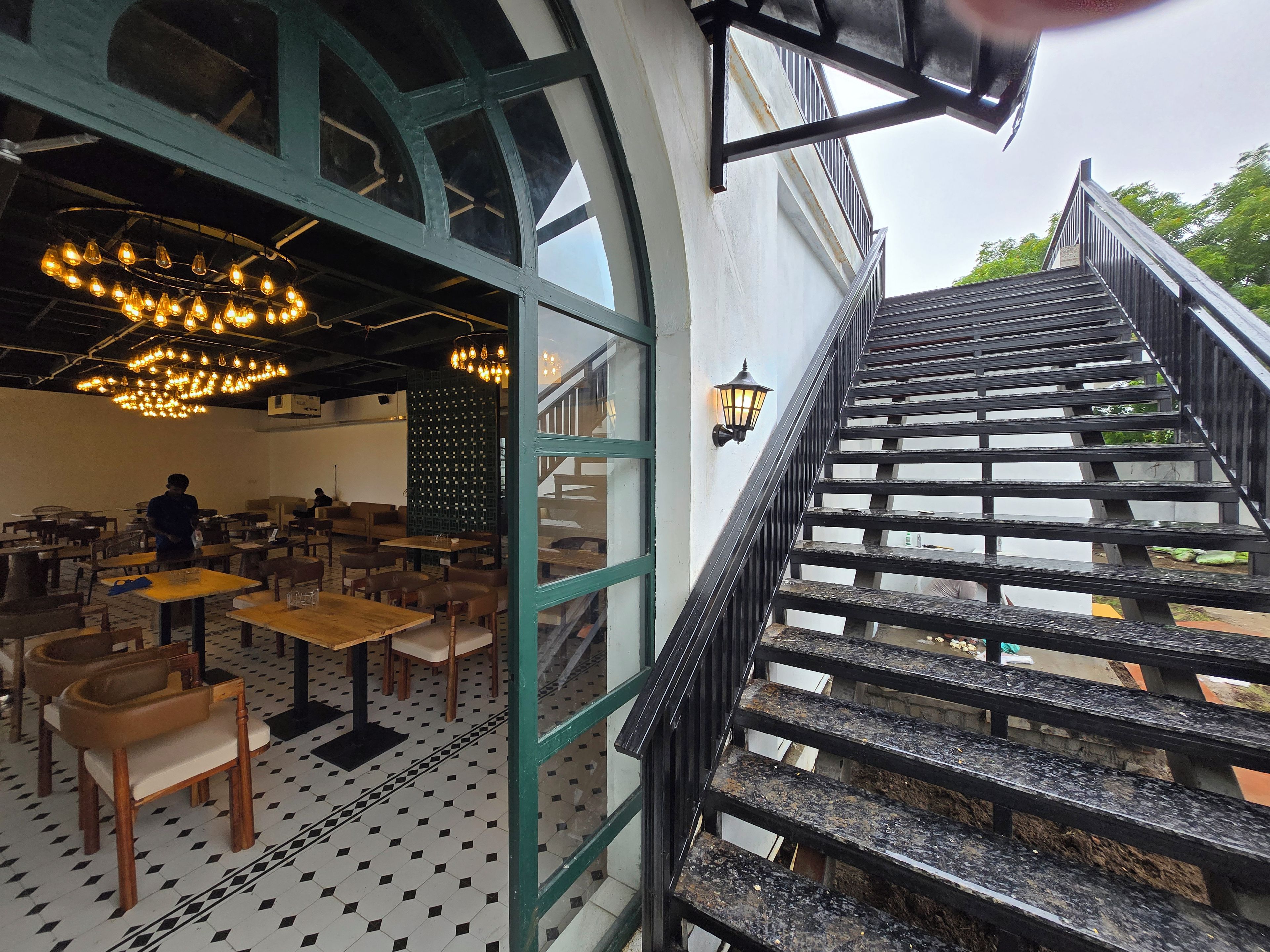 A restaurant interior with a staircase leading to an outdoor area.